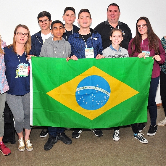 Ein Gruppenbild, bei dem eine brasilianische Flagge gehalten wird.