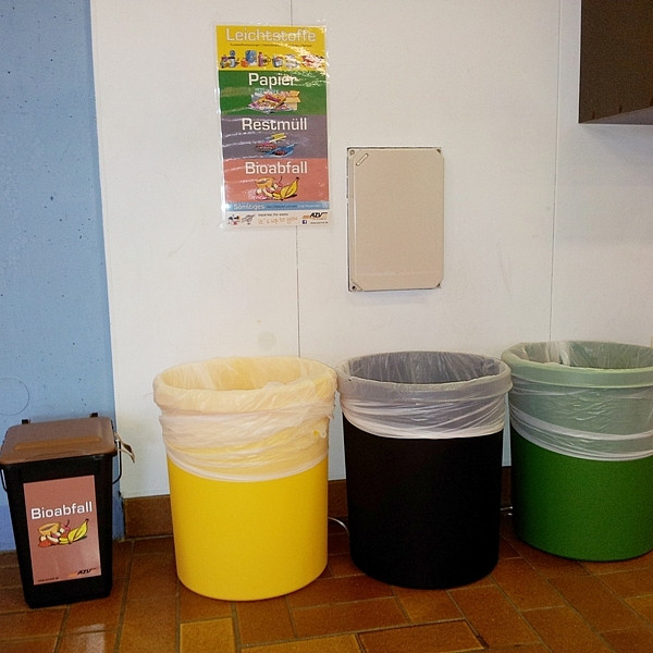 Vier Mülleimer in einer Schule