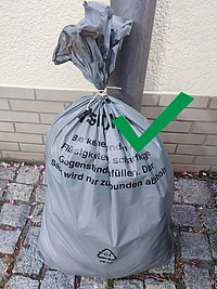 Ein Beispielbild, wie der Restmüllsack zugebunden werden soll.