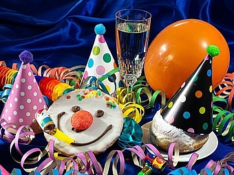 Faschingsfoto mit Krapfen, Luftschlangen und Partyhüten