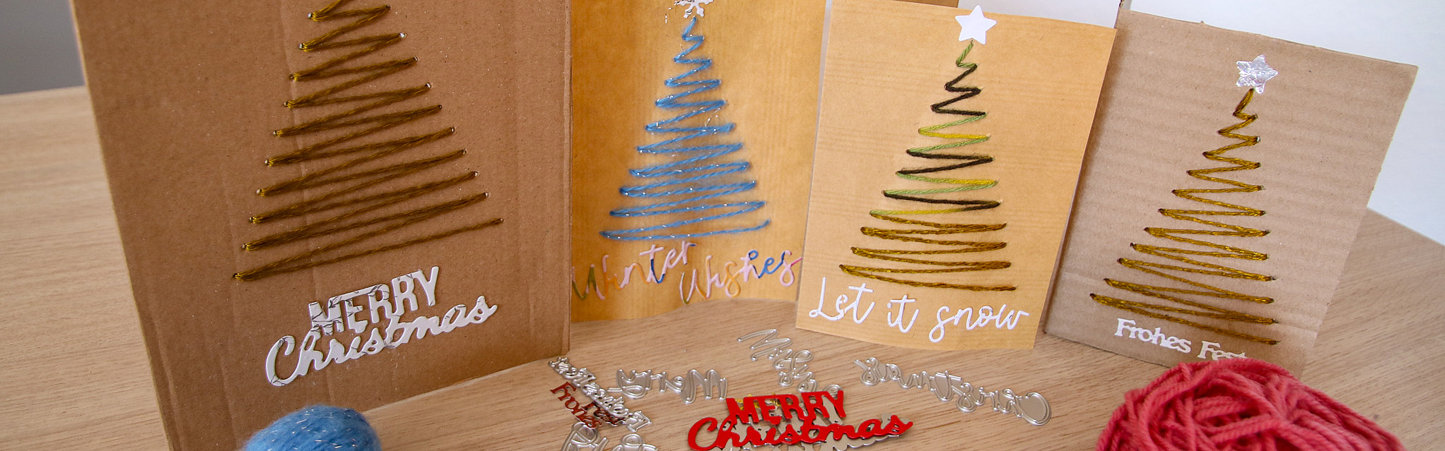 Bei der Weihnachtsbastelaktion 2025 werden aus Altpapier und verschiedenen Materialien kreative Weihnachtskarten gebastelt. Aus Wolle werden dabei Tannenbäume auf die Karten gestickt.