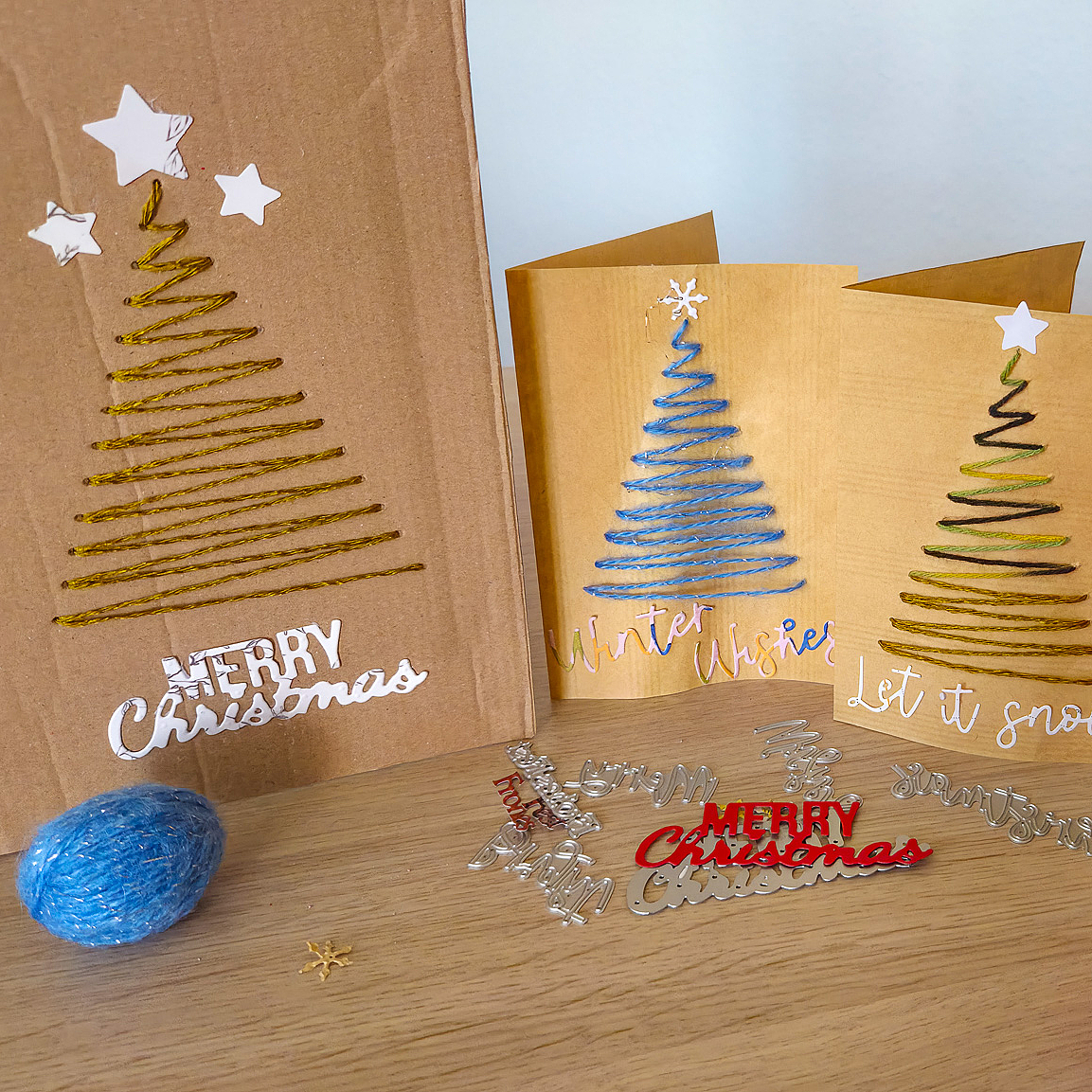 Bei der Weihnachtsbastelaktion 2025 werden aus Altpapier und verschiedenen Materialien kreative Weihnachtskarten gebastelt. Aus Wolle werden dabei Tannenbäume auf die Karten gestickt.